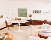 Retro-style living room with tulip sideboard and armchairs in foreground