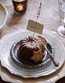 Small chocolate cake and name tag on festively set table