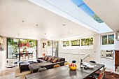 Modern extension with skylight and ribbon window - designer-style, open-plan living space with access to terrace