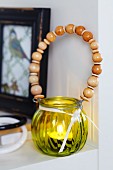 Yellow glass tealight holder with wooden beads threaded on wire handle