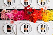 Festively set table with colour-coordinated confetti & flowers