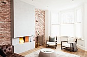 Coffee table in front of open fireplace in concrete chimney breast flanked by brick walls and armchair in corner