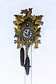 Traditional cuckoo clock with pendulum mounted on wall