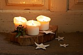 Lit candles and Christmas decorations on wooden board and floor