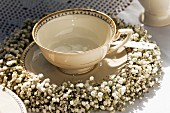 Nostalgic, gold-rimmed teacup festively decorated with wreath of gypsophila