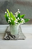Lily of the valley posy in glass container and garden scissors