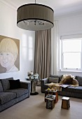 Large portrait of boy, mirrored retro table and brightly coloured coffee table in elegant interior with subdued colour scheme