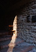 Stuhl auf einer Treppe in der Altstadt von Suvereto (Toskana, Italien)