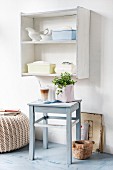 Upcycling - grey blue stool between pouffe and wooden mortar on floor below nostalgic crockery on shelf unit