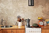 Kitchen counter with wooden doors and retro electric cooker against wall with rustic structured paint effect