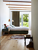 View into the bedroom with double bed and animal fur carpet