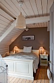 Wood-clad, attic bedroom with white double bed