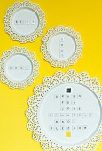 Letters stuck on flat magnets on round metal panels with lace edging used as noteboards