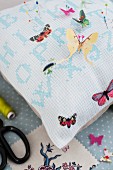 Hand-sewn pin cushion with butterfly motifs
