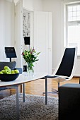 Moderner Coffeetable mit Klassiker Flair auf Flokatiteppich, eleganter, weisser Schalenstuhl mit schwarzen Polstern