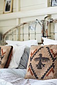 Scatter cushions with heraldic bird motif on striped bed linen