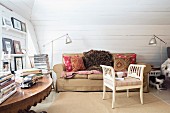 White, rustic wooden stool with armrests in front of sofa in pleasant attic room