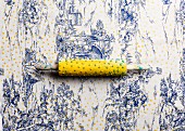 Printing yellow polka-dots on toile de jouy tablecloth using a modified rolling pin