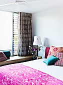 Patterned bedspread on double bed in modern bedroom