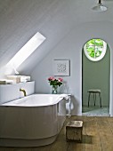 Philippe Starck bathtub with antique bronze tap fitting in purist bathroom
