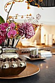 Reflective vase of flowers and gas stove in blurred background