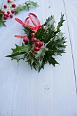 Holly sprigs with berries and leather ribbon (Christmas decoration)
