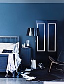 Mood indigo - standard lamp with glossy lampshade between bed and wardrobe; partially visible classic chair on cowhide rug