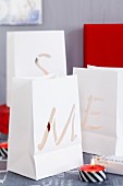 Paper-bag tealight lanterns with cut-out letters