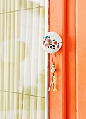 Retro furniture knob with floral motif and small tassel on cupboard door
