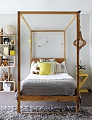 Teenager's bedroom in pale grey with lemon yellow accents and wooden bed with canopy