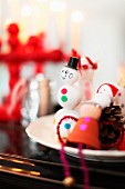 Schneemann-Figur aus weissen Kugeln und Weihnachtsdeko auf Teller