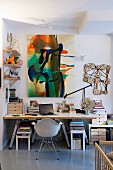 Contemporary painting and objets d'art in study with simple desk on trestles and classic shell chair