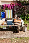 Beach bags on weathered bench in summery garden