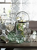 Table arrangement of elegant, country-house-style glass vessels and decorative white orchid flowers in champagne cooler