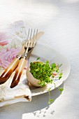Plate decoration; alfalfa sprouts in halved eggshell next to cutlery and napkin on plate