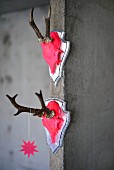 Two hunting trophies painted neon pink hanging on concrete wall