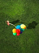 Ein Mädchen hält Bündel Luftballons (Aufsicht)