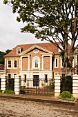 Grand, traditional manor house with closed entrance gates in London