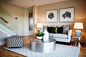 Moderne Lounge mit Sofa, Hocker, Teppich, Metalltisch und Beistelltischen mit Lampen