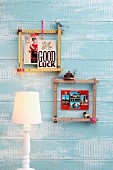 Square frames made from folding rulers fixed with cords hanging on sky blue wooden wall