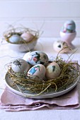 Easter eggs decorated with animal motifs in straw nest
