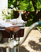 Strawberries and lemongrass lemonade in picnic basket on bicycle in garden