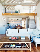 Open-plan living area with mezzanine and exposed roof beams in modern holiday home