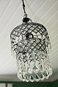 Vintage pendant lamp with glass pendants suspended from white wooden ceiling