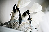 White bags tied with black ribbons in wire basket
