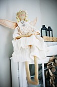 Angel doll sitting on cupboard