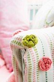 Green and pink crocheted roses on blanket