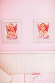 Two pictures of cherubs on pink wall above white, wooden child's bed