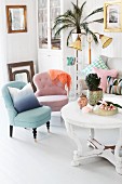 Pastel easy chairs, white, round coffee table with carved base, standard lamp and potted palm on plant stand