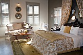 Double bed with canopy over headboard in elegant, country-house style bedroom with closed shutters on windows